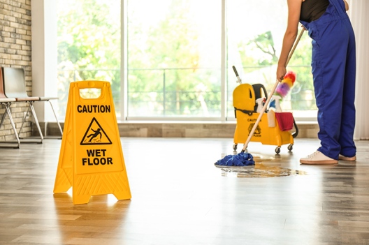 Safety sign with phrase Caution wet floor and cleaner indoors. C